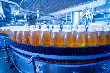 Modern bir içecek fabrikasında meyve suyu veya su için şişeli taşıyıcı bant