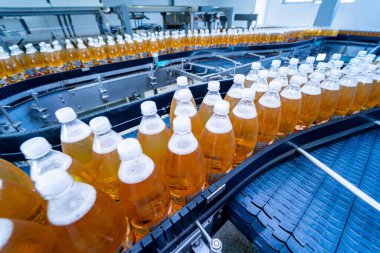 Modern bir içecek fabrikasında meyve suyu veya su için şişeli taşıyıcı bant