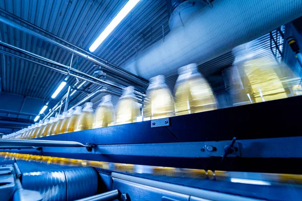 Transportband met flessen voor sap of water in een moderne drankfabriek — Stockfoto