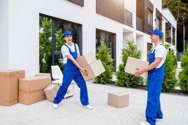 İki nakliye şirketi çalışanı bir minibüse kutu yüklüyorlar..