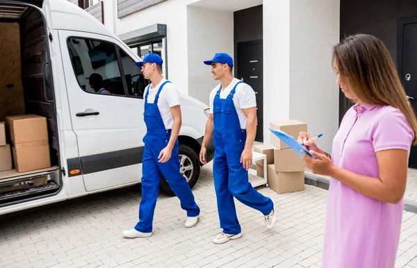 Két költöztető cég dolgozói kirakodás dobozok minibusz az ügyfelek otthonában — Stock Fotó