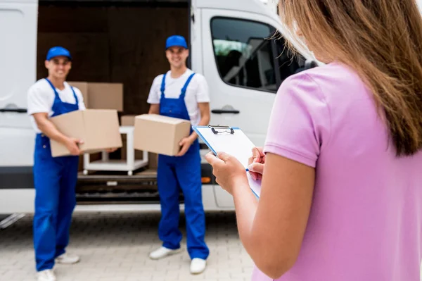 Két költöztető cég dolgozói kirakodás dobozok minibusz az ügyfelek otthonában — Stock Fotó