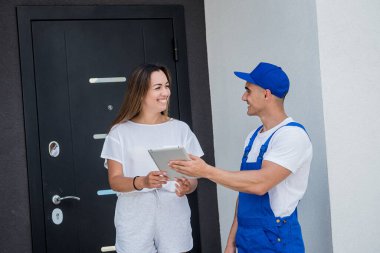 Genç kurye evde genç bir bayana mal getiriyor.