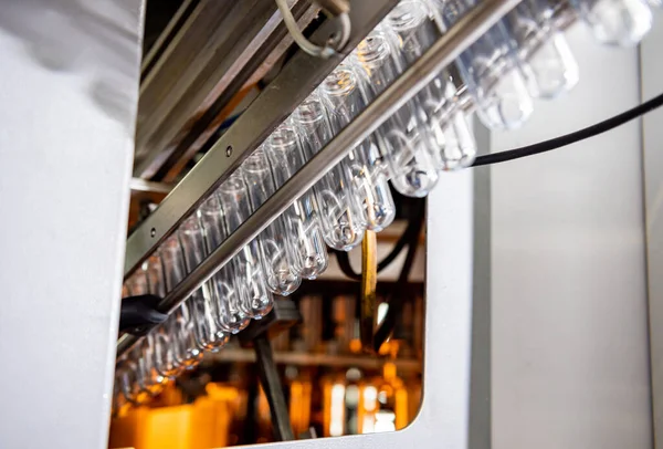 Máquina de enchimento automático derrama água em garrafas PET de plástico na moderna fábrica de bebidas. — Fotografia de Stock