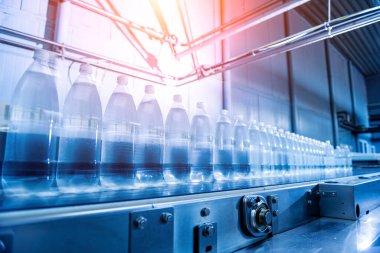 Modern bir içecek fabrikasında içme suyu şişeleriyle taşıma bandı..