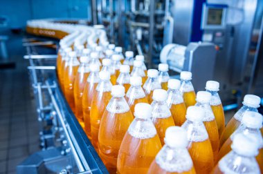Modern bir içecek fabrikasında meyve suyu veya su için şişeli taşıyıcı bant