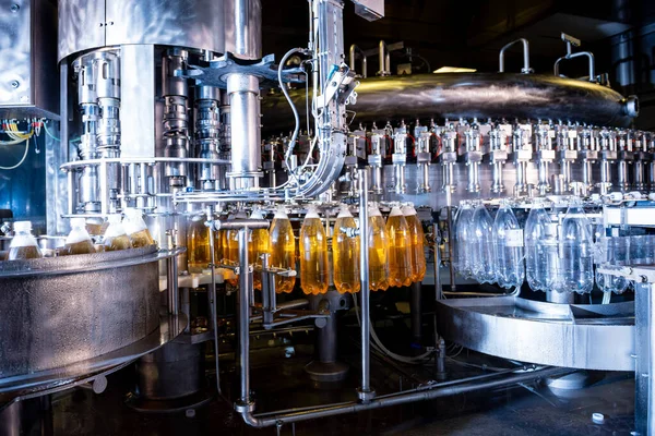 Automatische vulmachine giet water in plastic PET-flessen bij moderne drankfabriek. — Stockfoto