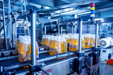 İçecek fabrikasında ambalaj hattı için modern bağlama ve taşıma makinesi.