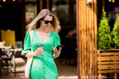 Şehrin arka planında keten rengi bir çantası olan güzel bir kadın..