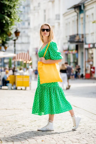 Mujer joven y hermosa con bolso ecológico de lino amarillo en el fondo de la ciudad. —  Fotos de Stock