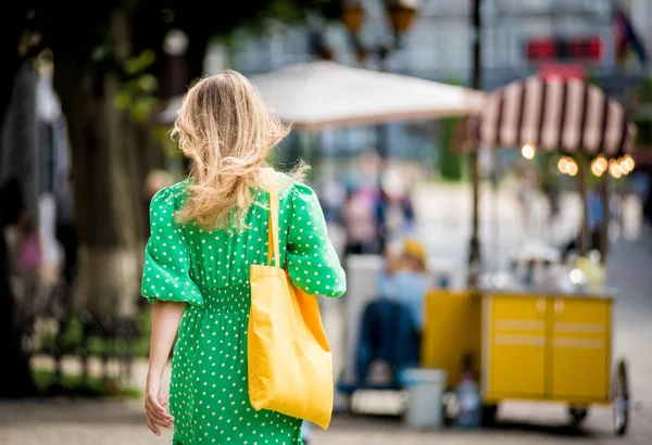 Młoda piękna kobieta z żółtą pościel ekologiczna torba na tle miasta. — Zdjęcie stockowe