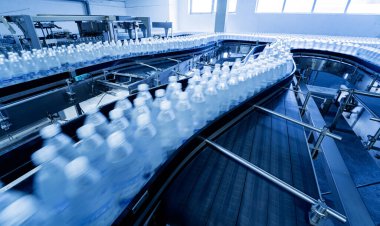 Modern bir içecek fabrikasında içme suyu şişeleriyle taşıma bandı..