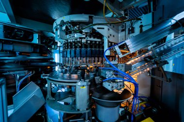 Modern içecek fabrikasında otomatik doldurma makinesi plastik PET şişelerine su doldurur.