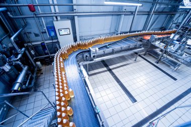 Modern bir içecek fabrikasında meyve suyu veya su için şişeli taşıyıcı bant