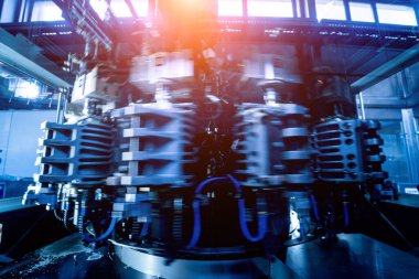 Modern içecek fabrikasında otomatik doldurma makinesi plastik PET şişelerine su doldurur.