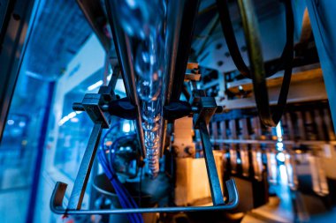 Modern içecek fabrikasında otomatik doldurma makinesi plastik PET şişelerine su doldurur.