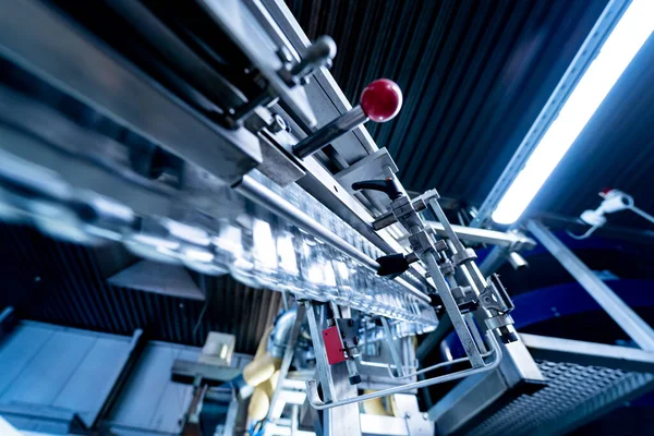 Modern içecek fabrikasında otomatik doldurma makinesi plastik PET şişelerine su doldurur.