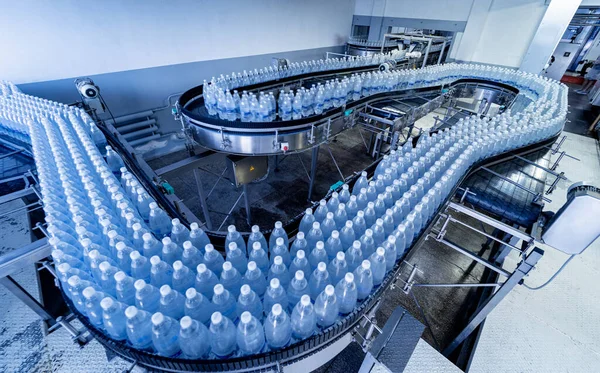 Transportband met flessen drinkwater in een moderne drankfabriek. — Stockfoto