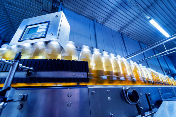 Conveyor belt with bottles for juice or water at a modern beverage plant