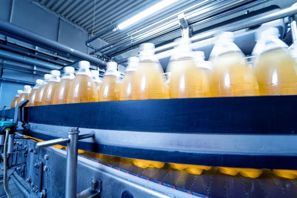Modern bir içecek fabrikasında meyve suyu veya su için şişeli taşıyıcı bant — Stok fotoğraf