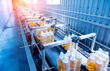 İçecek fabrikasında ambalaj hattı için modern bağlama ve taşıma makinesi.