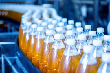 Modern bir içecek fabrikasında meyve suyu veya su için şişeli taşıyıcı bant