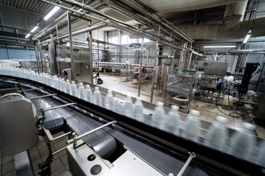 Modern bir içecek fabrikasında içme suyu şişeleriyle taşıma bandı..