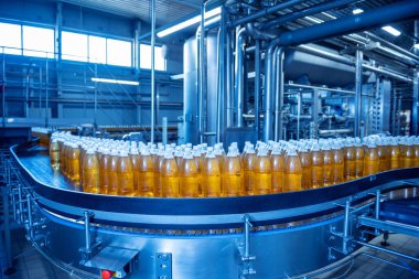 Modern bir içecek fabrikasında meyve suyu veya su için şişeli taşıyıcı bant