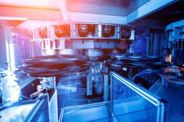 Modern içecek fabrikasında otomatik doldurma makinesi plastik PET şişelerine su doldurur.