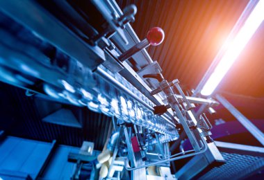 Modern içecek fabrikasında otomatik doldurma makinesi plastik PET şişelerine su doldurur.