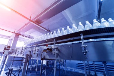 Modern bir içecek fabrikasında içme suyu şişeleriyle taşıma bandı..