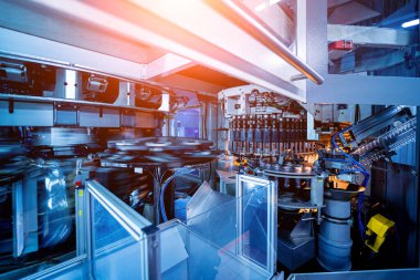 Modern içecek fabrikasında otomatik doldurma makinesi plastik PET şişelerine su doldurur.