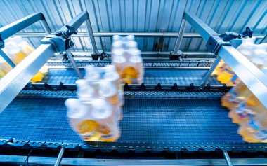 İçecek fabrikasında ambalaj hattı için modern bağlama ve taşıma makinesi.