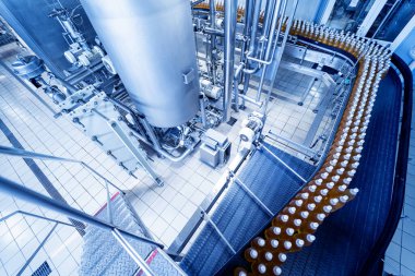 Modern bir içecek fabrikasında meyve suyu veya su için şişeli taşıyıcı bant