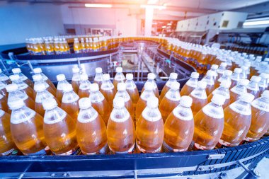 Modern bir içecek fabrikasında meyve suyu veya su için şişeli taşıyıcı bant