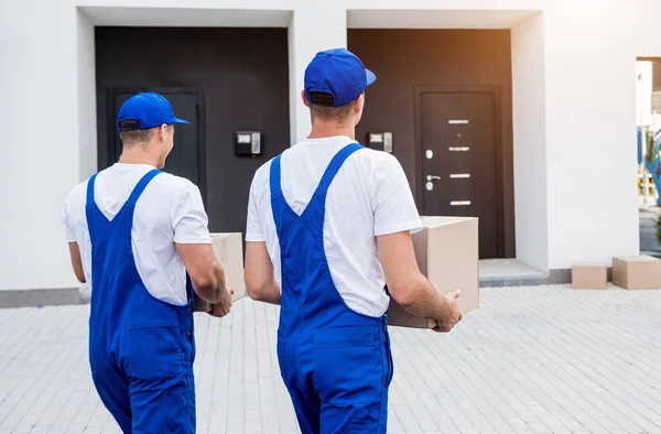 Due operai della società di rimozione che scaricano le scatole dal minibus nella nuova sede — Foto Stock