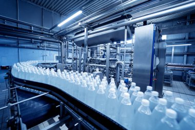 Modern bir içecek fabrikasında içme suyu şişeleriyle taşıma bandı..