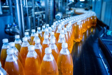 Modern bir içecek fabrikasında meyve suyu veya su için şişeli taşıyıcı bant