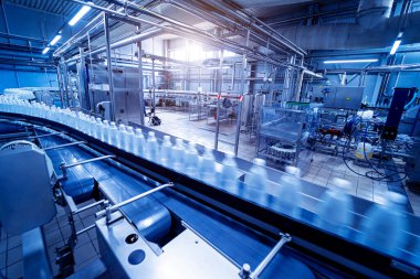 Modern bir içecek fabrikasında içme suyu şişeleriyle taşıma bandı..