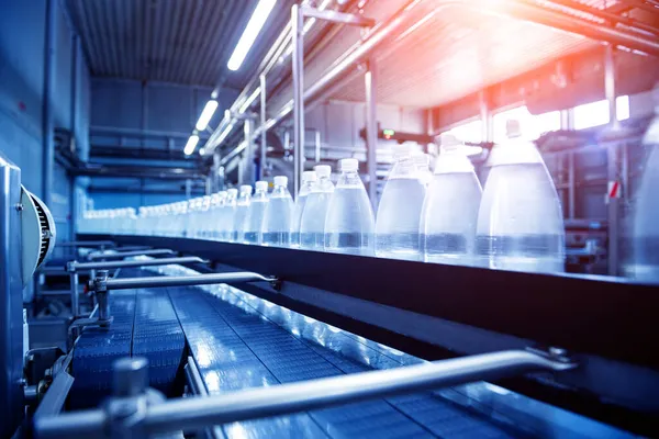 Transportband met flessen drinkwater in een moderne drankfabriek. — Stockfoto