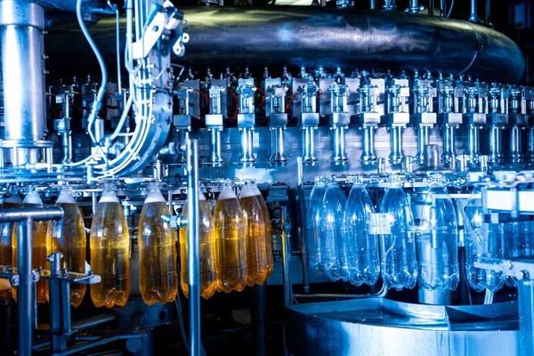 Автоматична машина наповнює воду пластиковими ПЕТ пляшками на сучасному заводі напоїв . — стокове фото