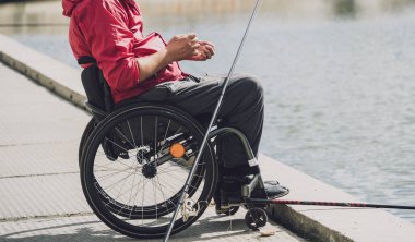 Tekerlekli sandalyede balıkçı teknesinde fiziksel engelli biri..