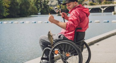 Tekerlekli sandalyede balıkçı teknesinde fiziksel engelli biri..