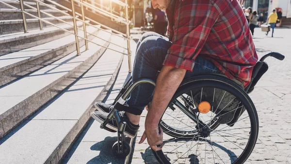 Junger Mann mit körperlicher Behinderung im Rollstuhl vor der Treppe — Stockfoto
