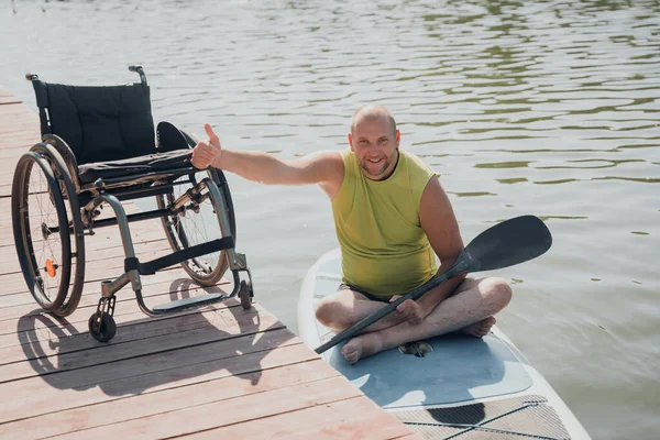 Osoba s tělesným postižením jízda na sup boardu — Stock fotografie