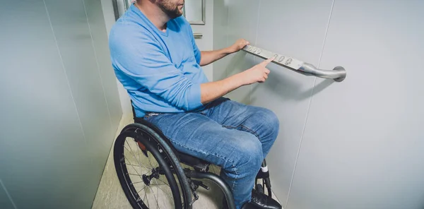 Pessoa com deficiência física numa cadeira de rodas que utiliza elevador no edifício — Fotografia de Stock