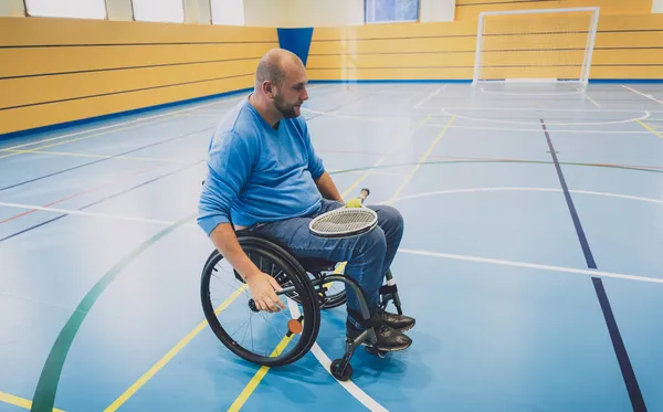 Erwachsener Mann mit körperlicher Behinderung im Rollstuhl spielt Tennis auf Tennishalle — Stockfoto