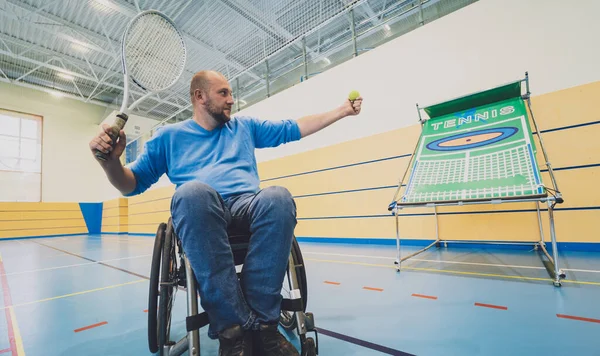Hombre adulto con discapacidad física en silla de ruedas jugando al tenis en pista de tenis cubierta —  Fotos de Stock