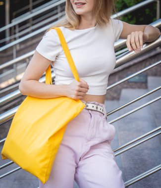 Şehrin arka planında keten çantalı güzel bir kadın..