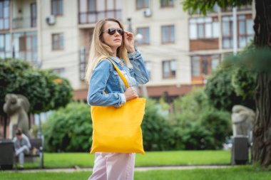 Şehrin arka planında keten çantalı güzel bir kadın..